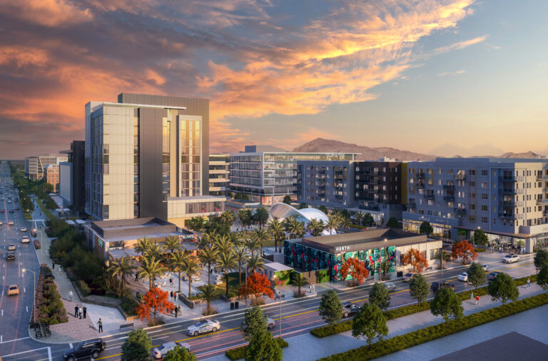 Aerial view of Novus Place and the main street, with mountains and a sunset in the background